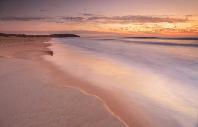 日落背景下的金色的沙滩