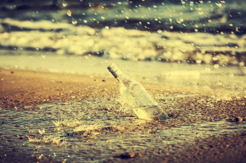雨中海滩上的玻璃瓶子