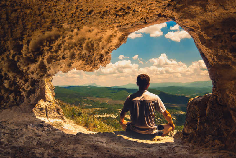 坐在洞穴里冥想的探险家