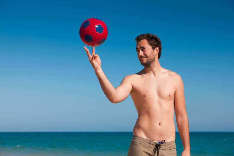 沙滩上玩平衡足球的男人