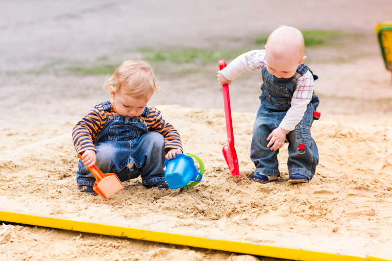 两个可爱的玩沙子的小孩