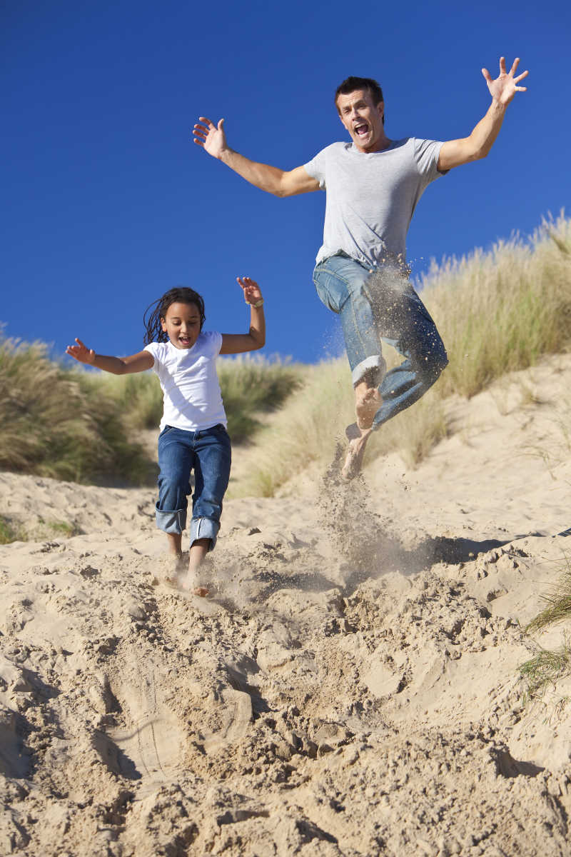 父亲和小女孩在沙滩上玩的很开心