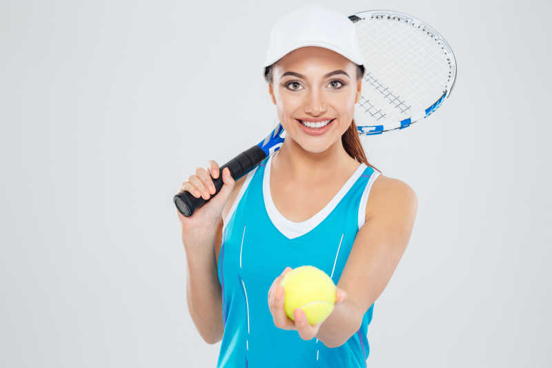 一个快乐的女网球运动员看着白色背景下