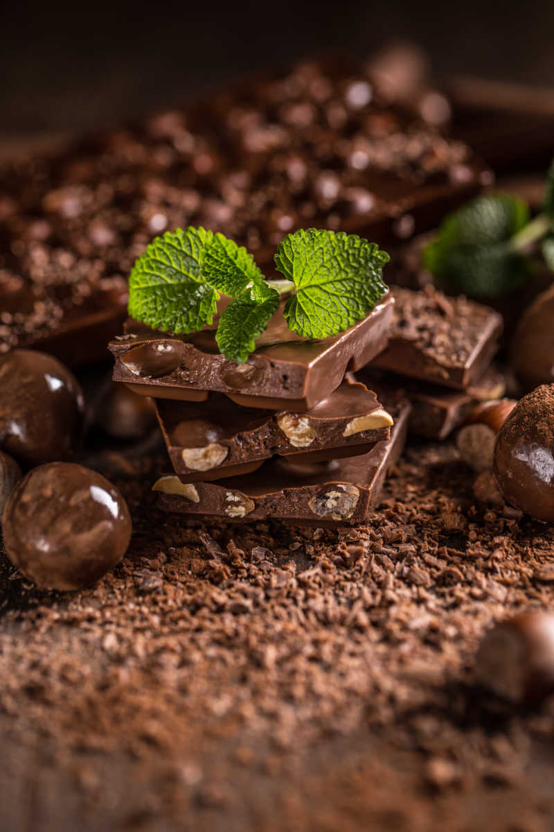 棕色背景下的榛子巧克力甜点和可可粉