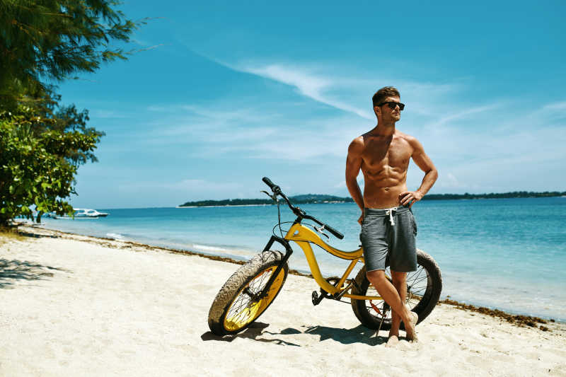 健身男模特骑自行车晒太阳