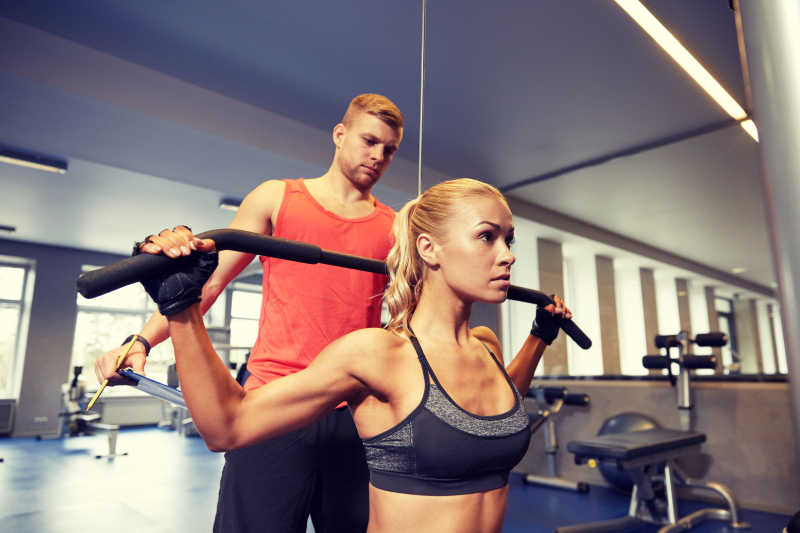 健身器材上的男女锻炼肌肉