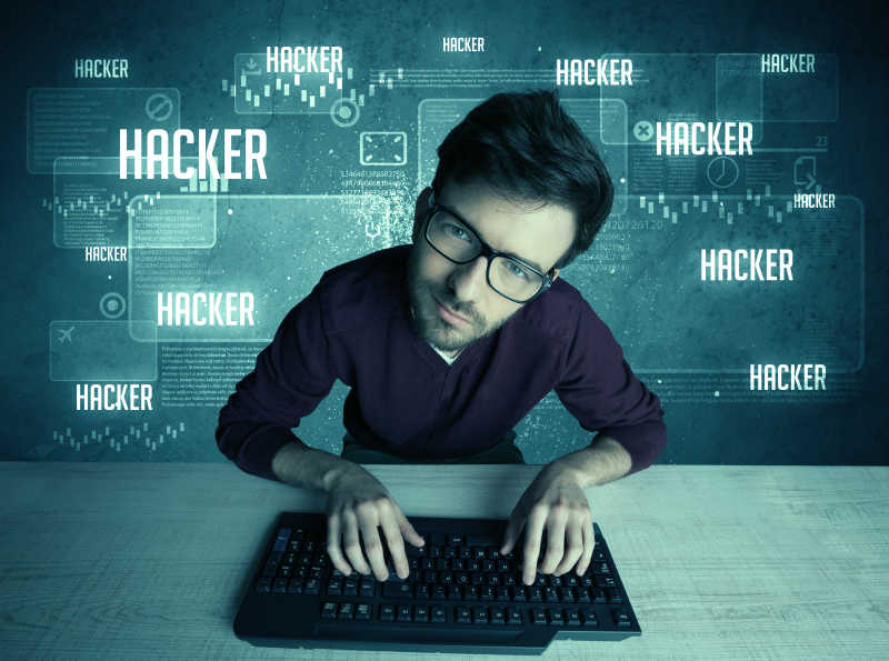 年轻英俊的黑客在电脑键盘上窃听互联网网站
