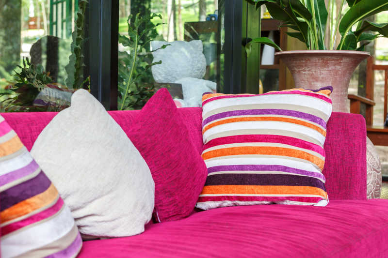 粉色沙发上颜色不同的靠垫