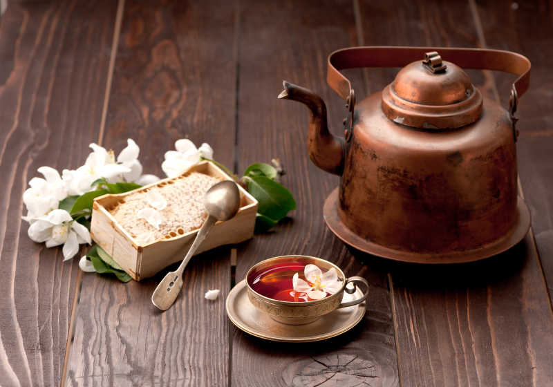 木纹理桌面上的古铜色的茶具和茶材料