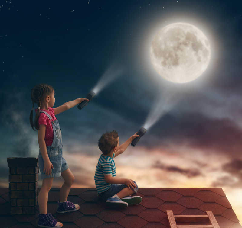 两个可爱的孩子坐在屋顶上看月亮