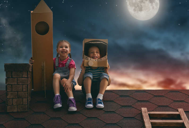 屋顶上的两个小孩在玩宇航员
