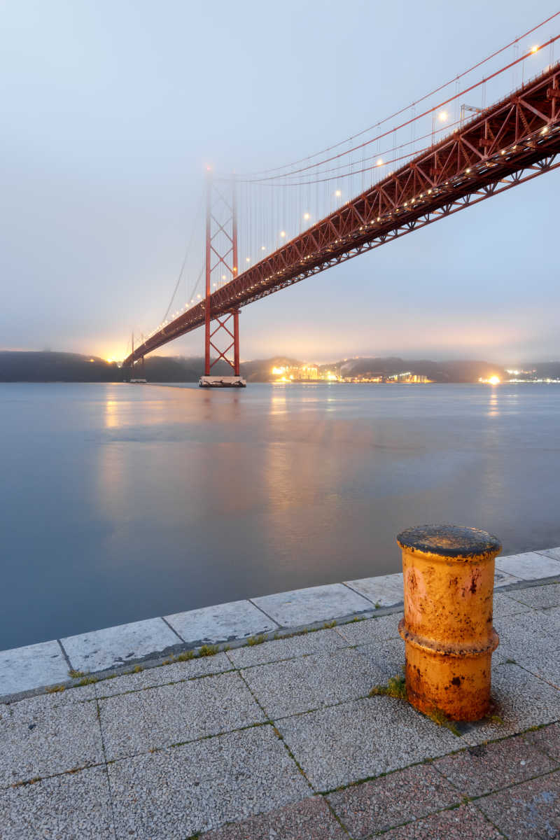 在日出和雾下凝视大桥