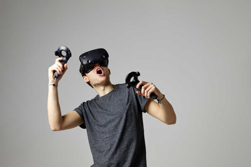 穿着虚拟现实眼镜玩游戏的人