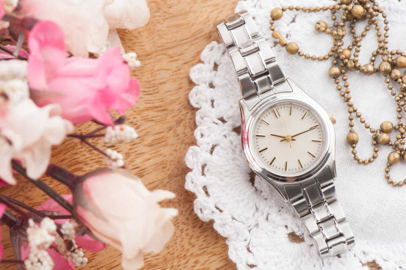 银色的女人手表和粉色的花朵