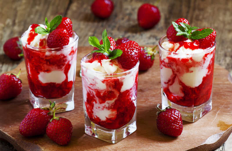 木桌上的草莓冰淇淋和草莓果实