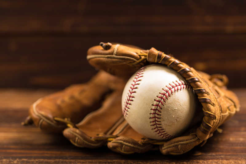 木质长板上的棒球手套与旧棒球