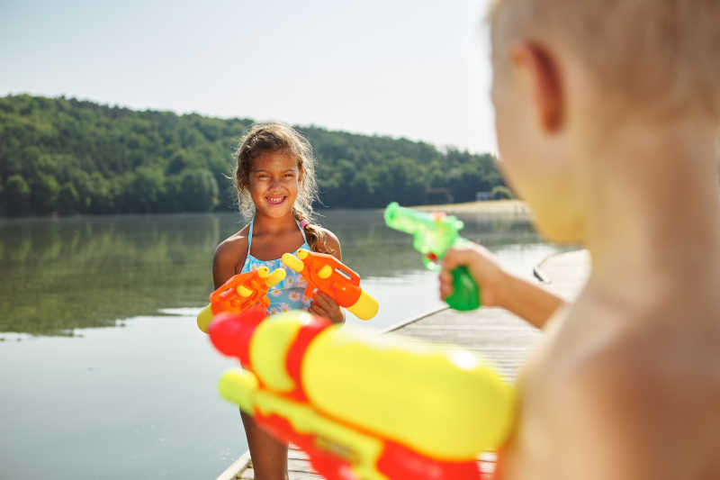 在湖边玩水枪的孩子们