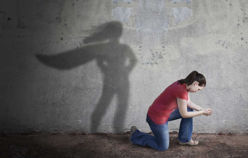 女孩地上的影子映射到墙上显现的超级英雄图影