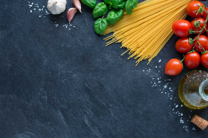 黑色面板一角的意大利面和蔬菜