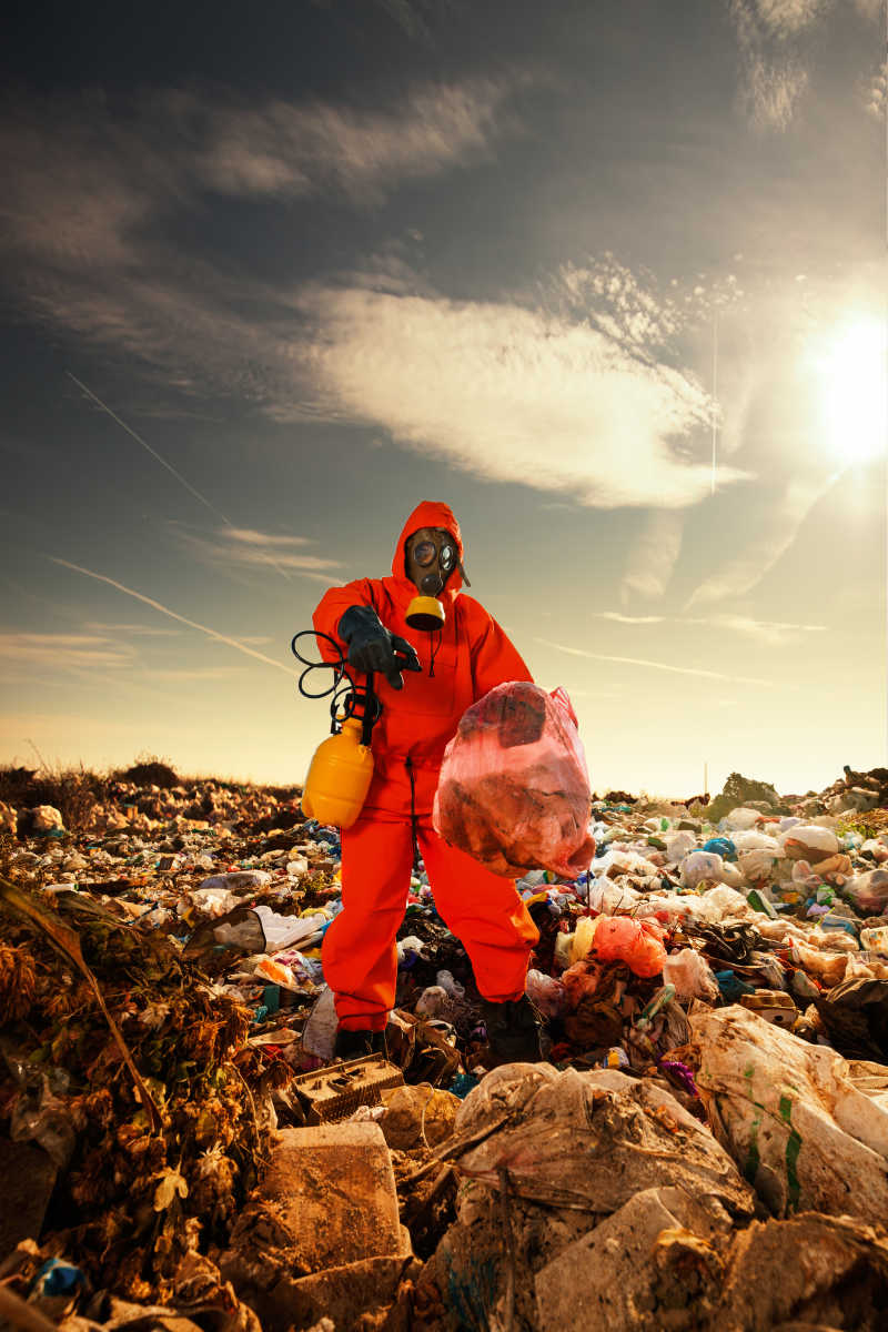 在垃圾填埋场穿着防护服检测垃圾的工作人员