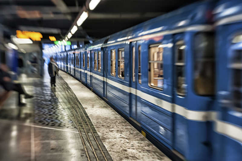 地铁站内行驶的蓝色地铁和乘客