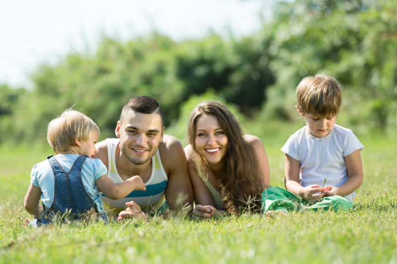 一家人在户外草地上幸福的微笑