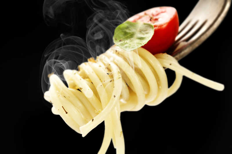 叉子上的意大利面和番茄特写