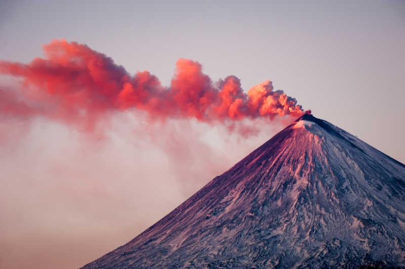 即将喷发的火山冒着红色的烟雾