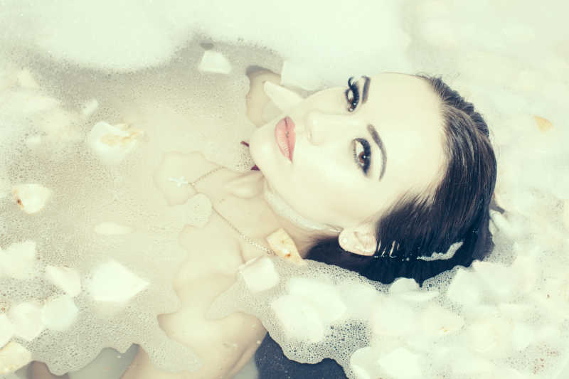 泡在花瓣水里洗澡的女人