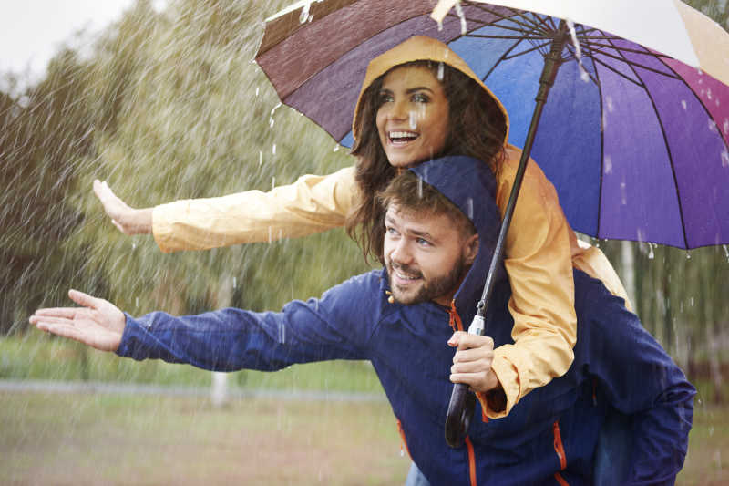 躲在雨中的雨伞下的情侣