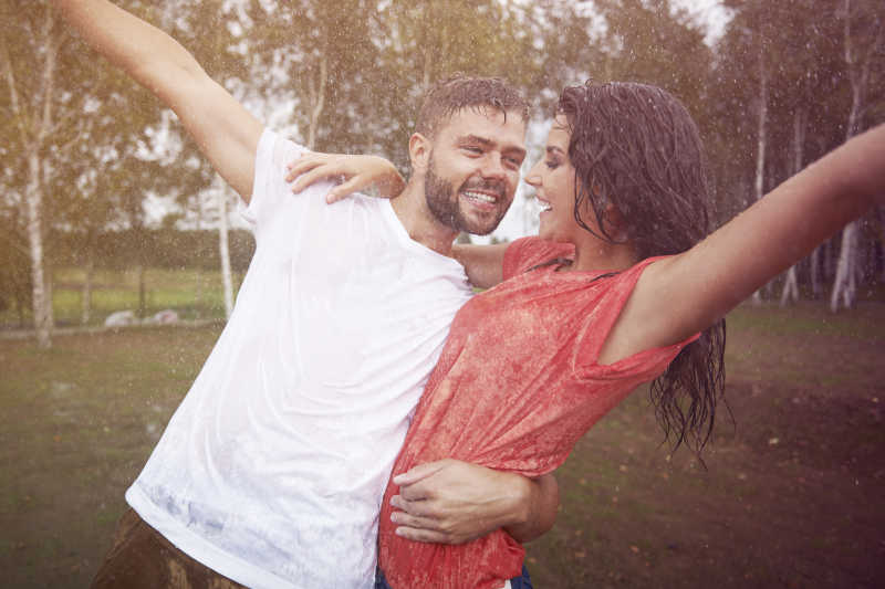 情侣夫妇在雨中开心的笑
