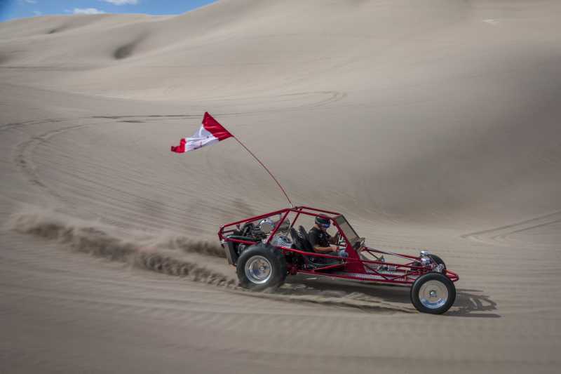 在沙丘上行驶的红色沙丘车