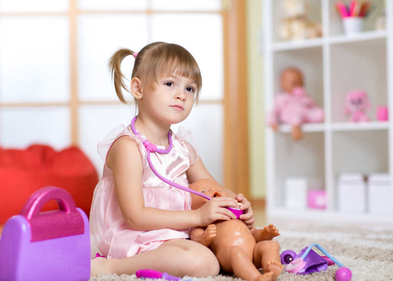 小女孩用听诊器给玩具娃娃听心脏
