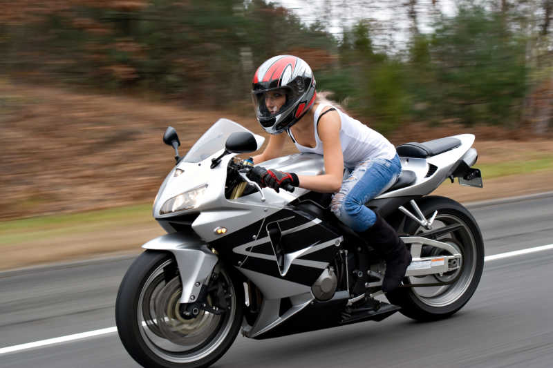 公路上戴着头盔骑摩托的女人