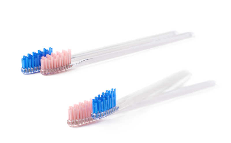 白色背景下的蓝色和粉红色牙刷