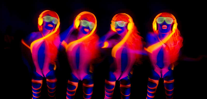 一群黑暗中涂着荧光颜料的迪斯科舞者