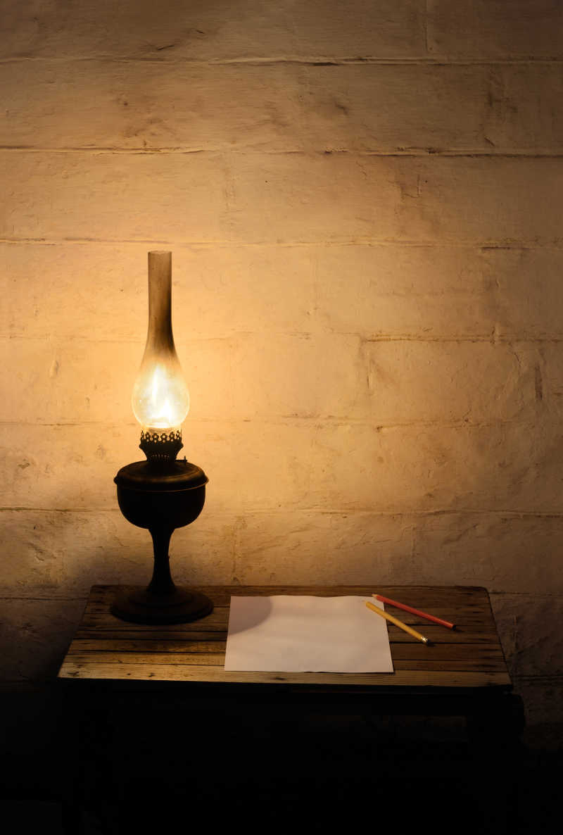 木桌上的煤油灯纸张和铅笔