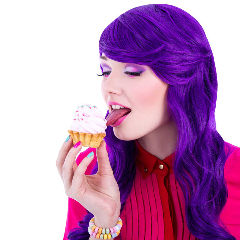 紫色头发的女人舔奶油蛋糕