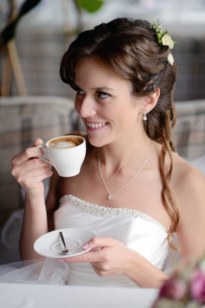 新娘穿着婚纱在室内喝咖啡