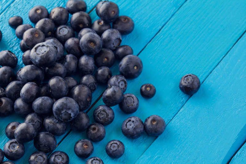 蓝色木板上的新鲜蓝莓