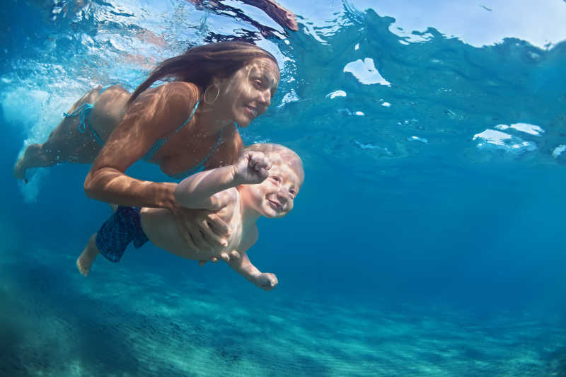 母亲带着孩子潜泳的幸福瞬间
