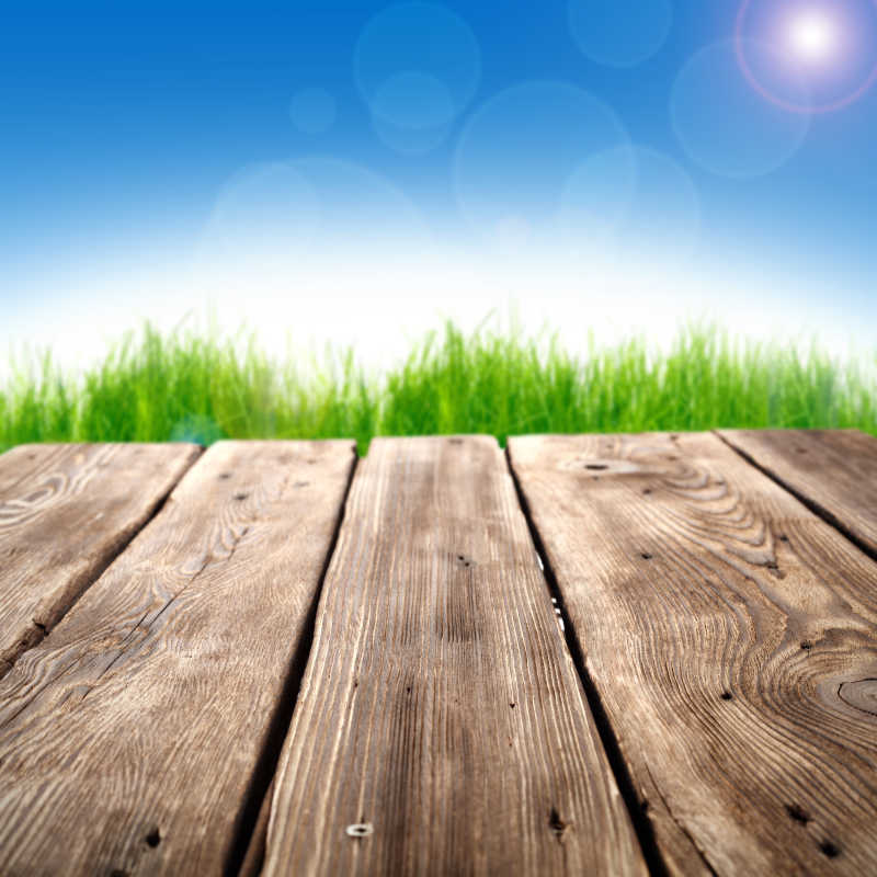 蓝天下草地背景前的木桌