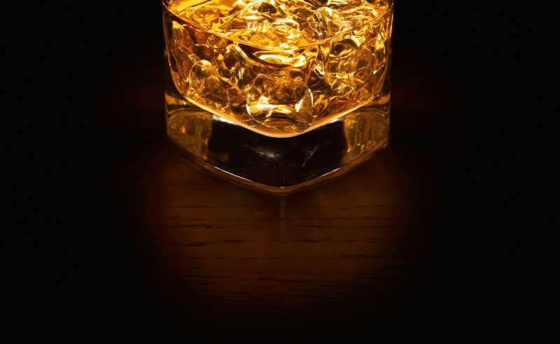 木桌上的威士忌装在玻璃杯里