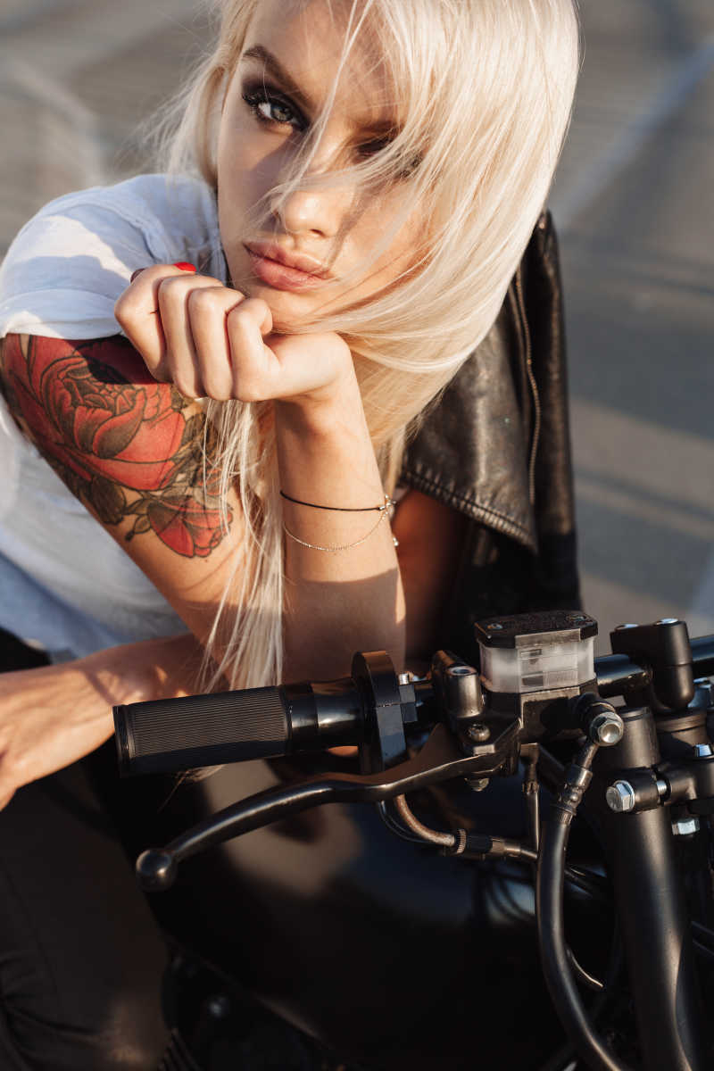 性感时尚的金发美女骑摩托车