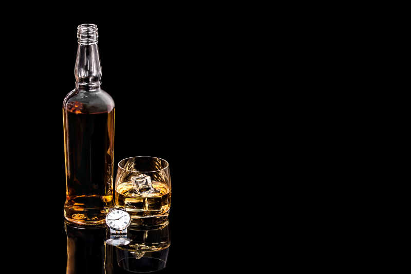 瓶和玻璃威士忌在黑色背景