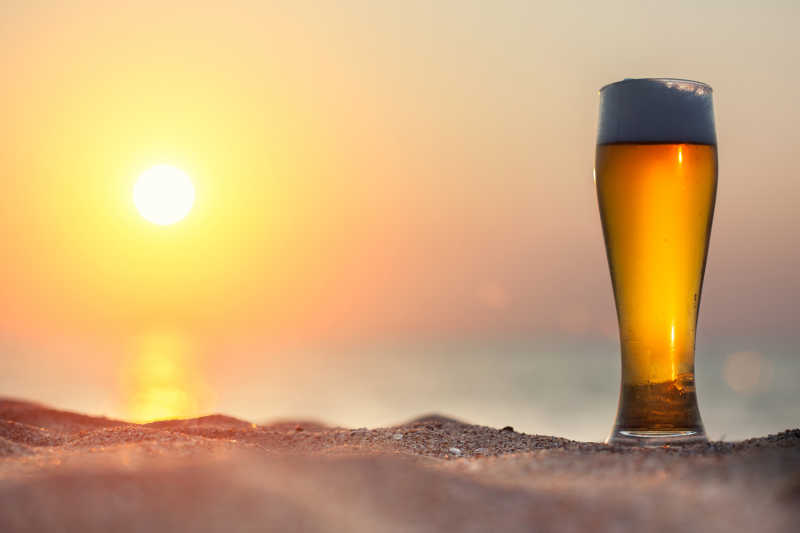 夕阳下的一杯橙色的啤酒