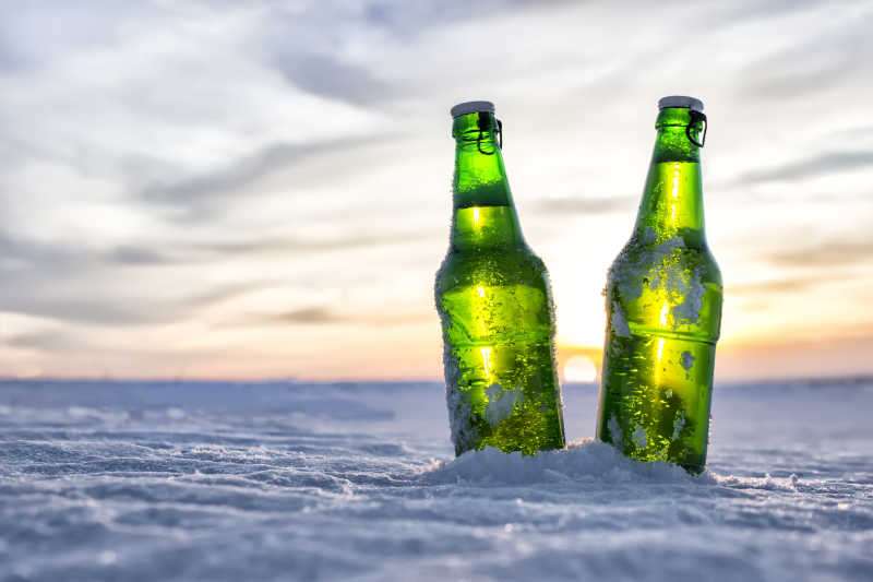 寒冷的日落地面上的一瓶冷啤酒