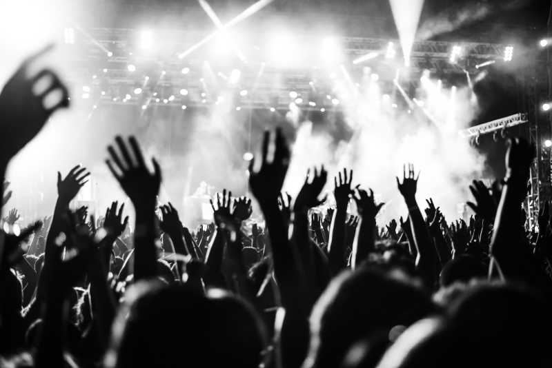 在音乐节上一群举起双手的歌迷