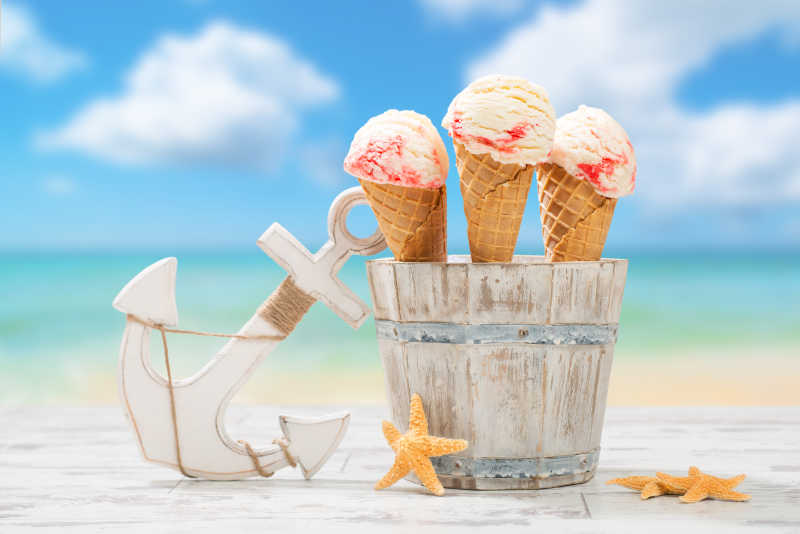 三支覆盆子冰淇淋放在海滩背景上