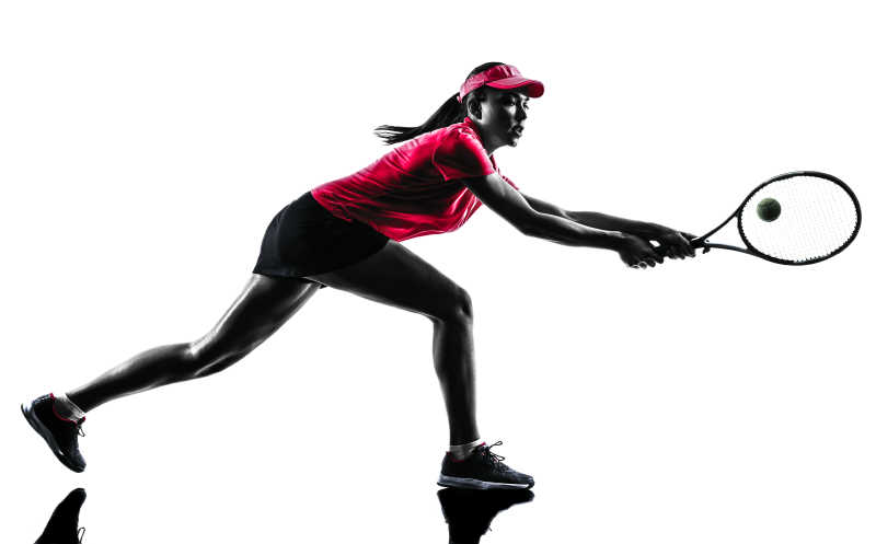 女子网球运动员奔跑接球的剪影